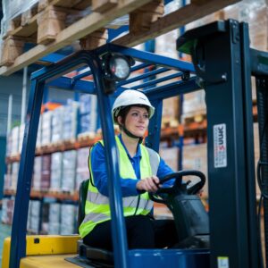 Forklift operator inside a warehouse working.